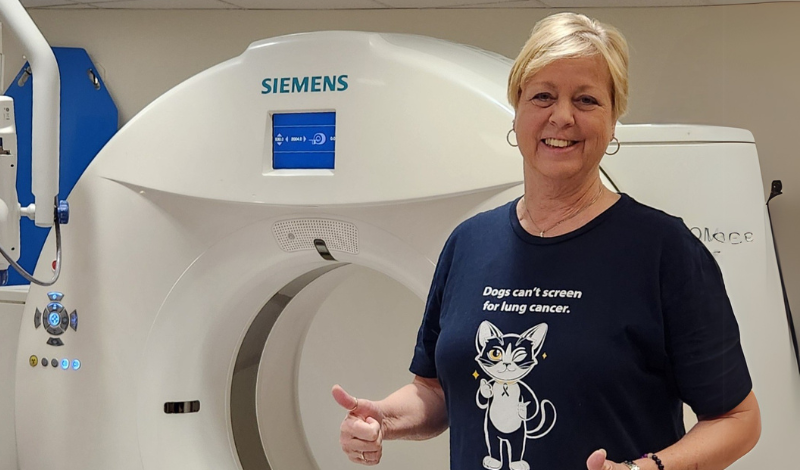 Wendy giving a thumbs up while standing in front of a CT scanner